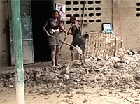ゴナイブ市内の中学校の一階で、泥をかき出す子ども。10月6日には1カ月遅れの新学期が始まる。