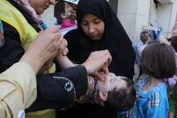 ユニセフとWHOの予防接種チームから予防接種を受ける女の子。