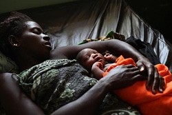 ユニセフが支援する病院で眠る赤ちゃんと母親（ギニア・ビザウ）