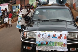 車にエボラに関する公用情報ポスターを貼って町を巡り、予防法を広めるスタッフ。