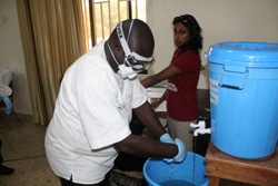 エボラ病棟での個人防護備品の使用ならびに取り外し手順はとても厳しく定められています。この研修は、国内1,200カ所の保健施設すべてに知識が普及するまで、実施されます。（シエラレオネ）