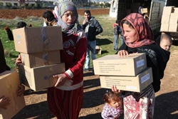冬服キットを受け取ったシリア難民の女性や子どもたち。