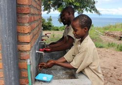 学校の手洗い所で石けんで手を洗う子どもたち。