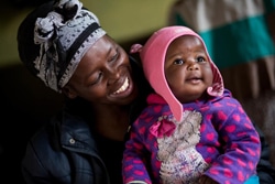 笑顔を見せる赤ちゃんとHIVと共に生きる母親。（南アフリカ）