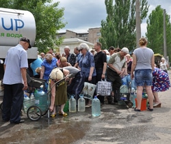 ウクライナ東部のルハーンシクで、トラックから水を汲む住民たち。