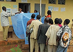 村の保健所で殺虫剤処理された蚊帳を受け取るために並ぶシェベディノ地区の人々。
