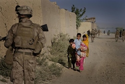 軍がパトロールする道を歩くアフガニスタンの子どもたち