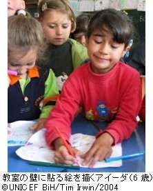 教室の壁に貼る絵を描くアイーダ（6歳）