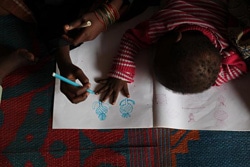 ユニセフの「子どもにやさしい空間」でお絵かきをする子ども