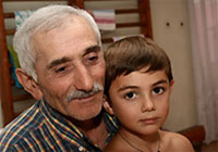 トビリシにある「希望」幼稚園に避難しているダト君（8歳）と祖父。