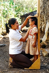 先住民の子どもの身長を測る看護師
