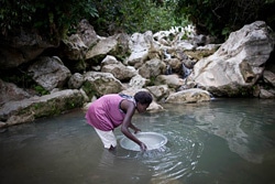 汚れた水源から水を汲む女性。（ハイチ）