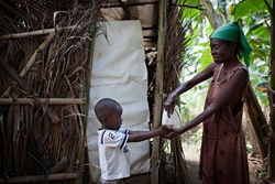 トイレを使用後、子どもの手をきれいな水で洗う母親。（ハイチ）