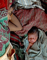 インド・ビハール州で、コシ川の洪水で家が押し流された次の日に生まれた赤ちゃんと母親。