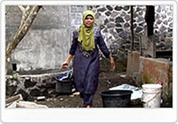 新しい貯水槽から水を汲む村人