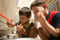 写真：ユニセフの支援で改善された、バクダッドの公共水道で、安全な水を飲む子どもたち。