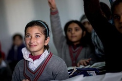 イラクの避難民キャンプにある学校で授業を受ける少女