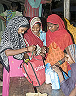 ユニセフが配布した衛生キットの中身を見るスンサリの避難所にいる女性たち。