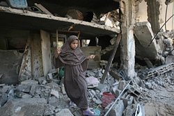 イスラエルによる空爆で破壊された自宅の中を歩く少女（ガザ地区）