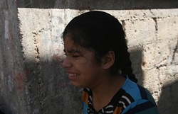 イスラエルによる空爆で家を破壊され、涙をみせる女の子。