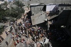 ガザ地区の空爆された家に集まる住民