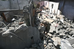 空爆で崩壊した、ガザ地区の家の中でたたずむ男の子