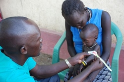ミンカマンのユニセフが支援する医療ケア施設で、保健員による栄養状態の検査を受ける子ども。