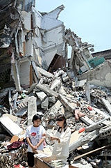 写真：都江堰で倒壊したアパートをみるアグネス大使。