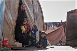 トルコ国境近くの非公式居住区で寒さから身を守るシリアの家族。(2019年11月撮影)