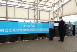 上海浦東国際空港でユニセフ・中国事務所代表から政府代表者へ医療従事者向けの支援物資を受け渡す様子。(2020年3月1日撮影) 