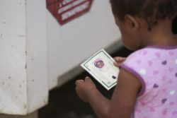 ERMで受け取った自分の身分証明書を見つめるブラジル人のアンゴラちゃん(1歳)。(2020年2月5日撮影)