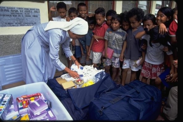 内戦後、ディリの小学校でユニセフから支給された教材と受け取る子どもたち。(2000年1月撮影)