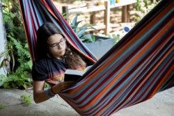 パナマ・ガンボアで勉強の後に自宅の外にあるハンモックの中で読書をする15歳のローラさん。(2020年4月17日撮影)