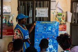 南スーダンで、予防接種のために子どもを連れてきた母親たちに、コロナウイルス感染予防の方法について伝える保健スタッフ。