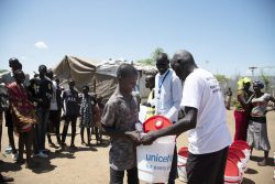 バケツと石けんを受け取る男の子。(南スーダン)