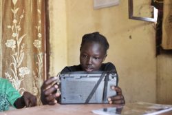 ジュバの自宅で、ラジオを通じて英語と理科の授業に取り組む14歳の女の子。(南スーダン、2020年5月21日撮影)