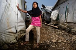 紛争から逃れ、マラウィ(Marawi)郊外にある避難所の仮設住居の横に立つ12歳の女の子。(フィリピン、2019年9月撮影)
