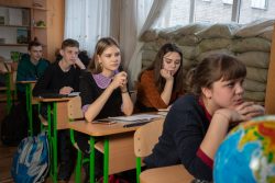 ユニセフとパートナー団体が設立した家族支援センターで、砲撃に備えて窓辺に土のうが積まれた教室で勉強する子どもたち。(ウクライナ、2019年2月撮影)