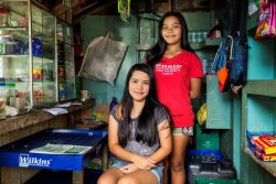 近所で経営しているコンビニエンスストアで店番をする17歳のアレナさん(左)と20歳のアリッサさん(右)姉妹。収入は学費に充てるものだったが、最近は家族の食費に充てられている。(フィリピン、2020年8月10日撮影)