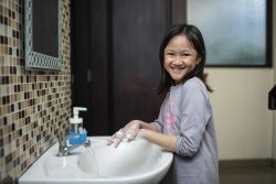 ジャカルタの自宅で、石けんを使って手を洗う8歳のアデリーナさん。(インドネシア、2020年9月1日撮影)