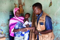 ソーシャルワーカーから現金給付支援を受け取る家族。(ブルキナファソ、2020年9月撮影)