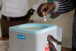 ジュバのヘルスケア・センターで保冷箱からワクチンを取り出す様子。(南スーダン、2020年10月撮影)