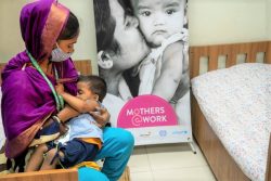 ダッカにある保育所で赤ちゃんに母乳を与える母親。(バングラデシュ、2020年6月撮影)