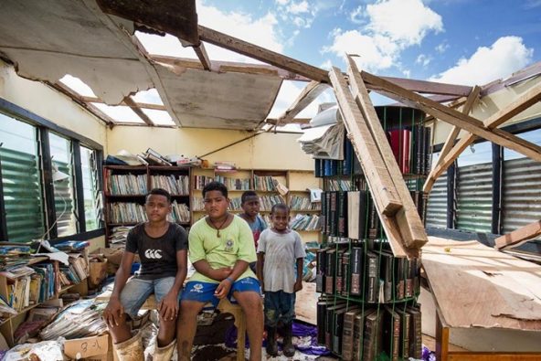サイクロン「Yasa（ヤサ）」によって損壊した学校の図書室と、被災した子どもたち。（フィジー、2020年12月）