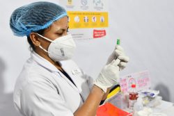 グワハティ医科大学病院で、インド血清研究所が製造したアストラゼネカ製薬のCOVID-19ワクチンの接種準備をする看護師。(インド、2021年1月16日撮影)