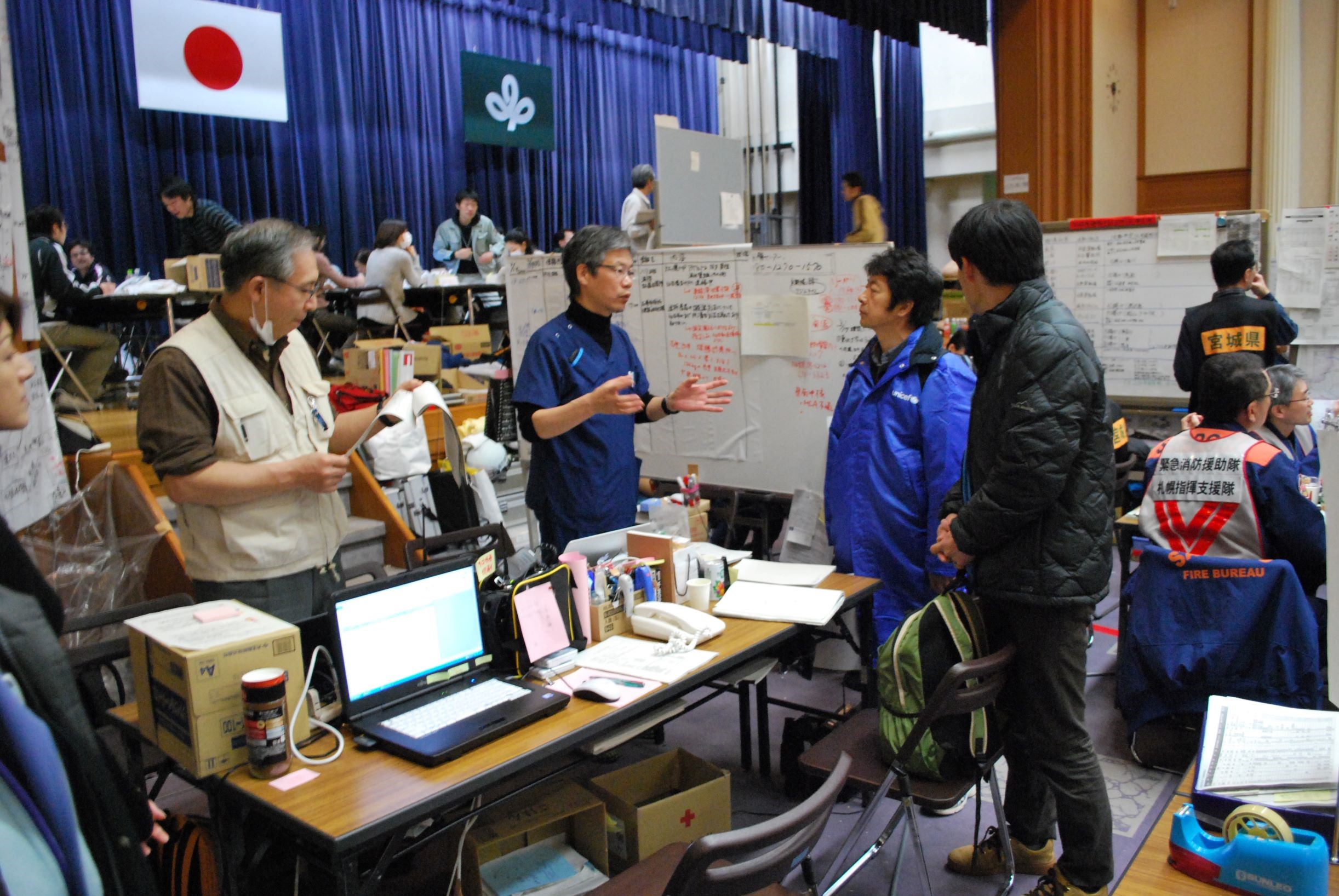 2011年3月 宮城県庁内の災害対策本部で協議する國井修医師（右から2番目）