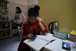 首都リマの自宅で宿題に取り組む15歳のダニエラさん。パソコンが自宅にないため、携帯アプリを通じて授業の映像を受信している。(ペルー、2020年9月撮影)
