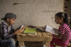 パレンシア(Palencia)の自宅で宿題をする11歳のジャスティンくんと8歳のメラニさん。(グアテマラ、2020年4月撮影)