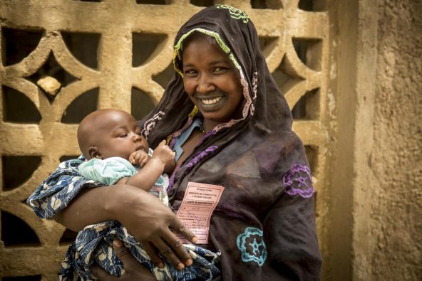予防接種を受けたマリアムくん（生後3カ月）を笑顔で抱っこする母親のアイサタさん。