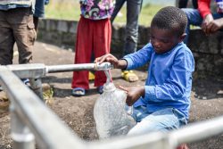北キブ州・サケでユニセフが支援する折りたたみ式水タンクから水を汲む子ども。(2021年6月2日撮影)